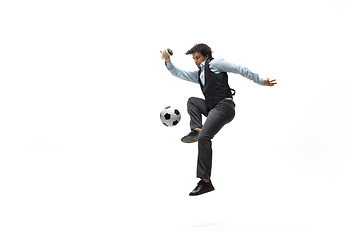 Image showing Man in office clothes playing football or soccer with ball on white background. Unusual look for businessman in motion, action. Sport, healthy lifestyle.