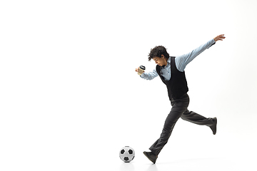 Image showing Man in office clothes playing football or soccer with ball on white background. Unusual look for businessman in motion, action. Sport, healthy lifestyle.