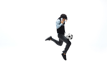 Image showing Man in office clothes playing football or soccer with ball on white background. Unusual look for businessman in motion, action. Sport, healthy lifestyle.