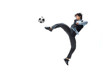 Image showing Man in office clothes playing football or soccer with ball on white background. Unusual look for businessman in motion, action. Sport, healthy lifestyle.