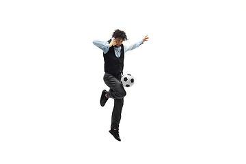 Image showing Man in office clothes playing football or soccer with ball on white background. Unusual look for businessman in motion, action. Sport, healthy lifestyle.