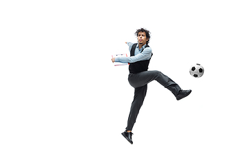 Image showing Man in office clothes playing football or soccer with ball on white background. Unusual look for businessman in motion, action. Sport, healthy lifestyle.