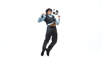 Image showing Man in office clothes playing football or soccer with ball on white background. Unusual look for businessman in motion, action. Sport, healthy lifestyle.