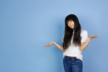 Image showing Portrait of young asian woman isolated on blue studio background