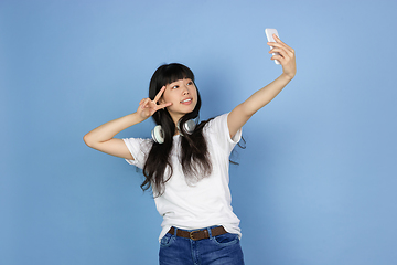 Image showing Portrait of young asian woman isolated on blue studio background