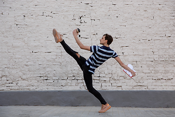 Image showing Jumping young buinessman in front of buildings, on the run in jump high