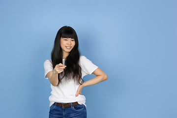 Image showing Portrait of young asian woman isolated on blue studio background