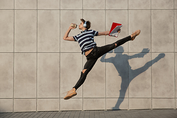 Image showing Jumping young buinessman in front of buildings, on the run in jump high