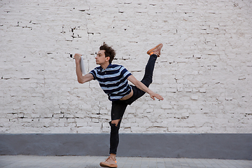 Image showing Jumping young buinessman in front of buildings, on the run in jump high