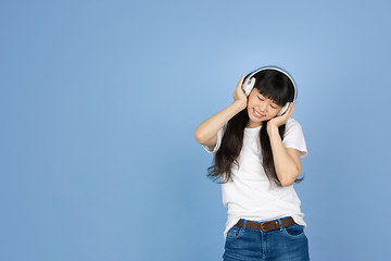 Image showing Portrait of young asian woman isolated on blue studio background