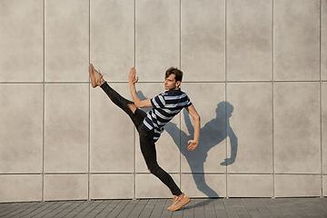 Image showing Jumping young buinessman in front of buildings, on the run in jump high