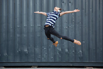 Image showing Jumping young buinessman in front of buildings, on the run in jump high