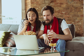 Image showing Excited football fans watching sport match at home, remote support of favourite team during coronavirus pandemic outbreak