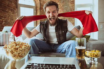 Image showing Excited football fan watching sport match at home, remote support of favourite team during coronavirus pandemic outbreak