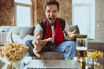 Image showing Excited football fan watching sport match at home, remote support of favourite team during coronavirus pandemic outbreak