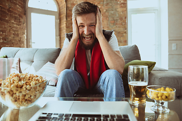 Image showing Excited football fan watching sport match at home, remote support of favourite team during coronavirus pandemic outbreak