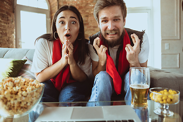 Image showing Excited football fans watching sport match at home, remote support of favourite team during coronavirus pandemic outbreak