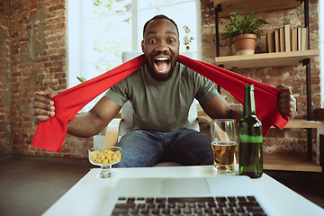 Image showing Excited football fan watching sport match at home, remote support of favourite team during coronavirus pandemic outbreak