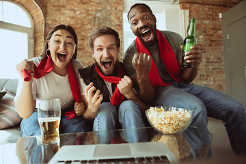 Image showing Excited football fans watching sport match at home, remote support of favourite team during coronavirus pandemic outbreak