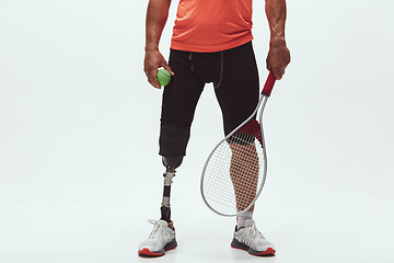 Image showing Athlete with disabilities or amputee isolated on white studio background. Professional male tennis player with leg prosthesis training and practicing in studio.