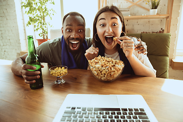 Image showing Excited football fans watching sport match at home, remote support of favourite team during coronavirus pandemic outbreak