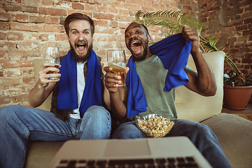 Image showing Excited football fans watching sport match at home, remote support of favourite team during coronavirus pandemic outbreak