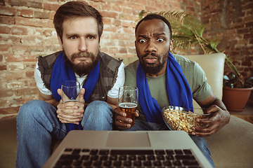 Image showing Excited football fans watching sport match at home, remote support of favourite team during coronavirus pandemic outbreak