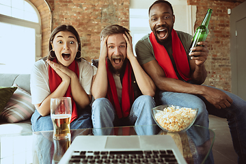 Image showing Excited football fans watching sport match at home, remote support of favourite team during coronavirus pandemic outbreak