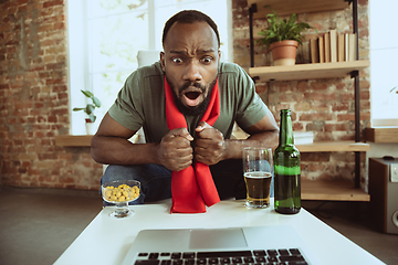 Image showing Excited football fan watching sport match at home, remote support of favourite team during coronavirus pandemic outbreak