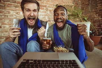 Image showing Excited football fans watching sport match at home, remote support of favourite team during coronavirus pandemic outbreak