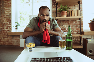 Image showing Excited football fan watching sport match at home, remote support of favourite team during coronavirus pandemic outbreak