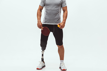 Image showing Athlete with disabilities or amputee isolated on white studio background. Professional male table tennis player with leg prosthesis training and practicing in studio.