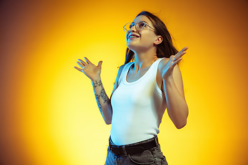 Image showing Portrait of young caucasian woman isolated on gradient yellow studio background