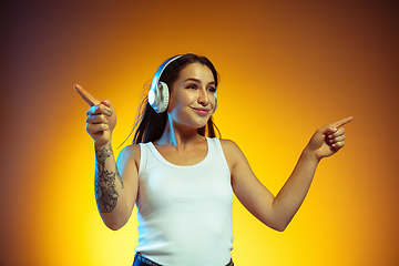 Image showing Portrait of young caucasian woman isolated on gradient yellow studio background