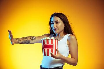 Image showing Portrait of young caucasian woman isolated on gradient yellow studio background