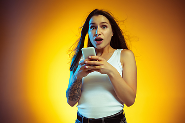 Image showing Portrait of young caucasian woman isolated on gradient yellow studio background