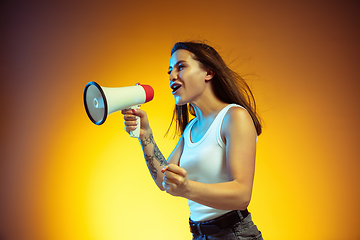 Image showing Portrait of young caucasian woman isolated on gradient yellow studio background