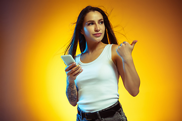 Image showing Portrait of young caucasian woman isolated on gradient yellow studio background