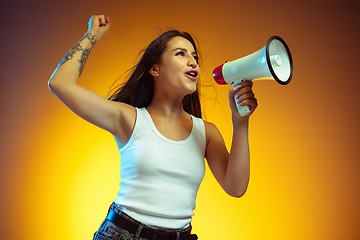 Image showing Portrait of young caucasian woman isolated on gradient yellow studio background