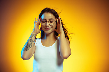 Image showing Portrait of young caucasian woman isolated on gradient yellow studio background