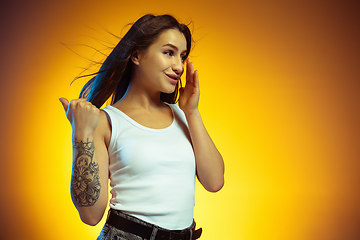 Image showing Portrait of young caucasian woman isolated on gradient yellow studio background