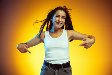 Image showing Portrait of young caucasian woman isolated on gradient yellow studio background