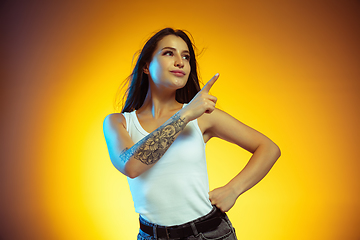 Image showing Portrait of young caucasian woman isolated on gradient yellow studio background