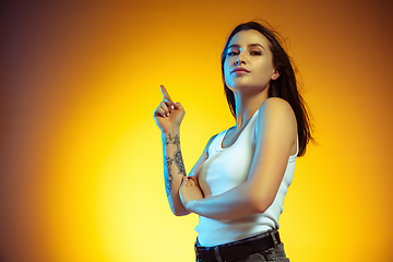 Image showing Portrait of young caucasian woman isolated on gradient yellow studio background