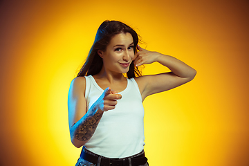 Image showing Portrait of young caucasian woman isolated on gradient yellow studio background