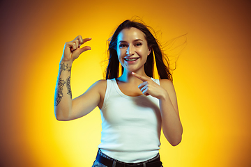 Image showing Portrait of young caucasian woman isolated on gradient yellow studio background