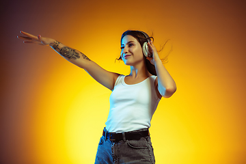 Image showing Portrait of young caucasian woman isolated on gradient yellow studio background