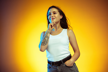 Image showing Portrait of young caucasian woman isolated on gradient yellow studio background