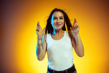 Image showing Portrait of young caucasian woman isolated on gradient yellow studio background