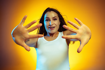 Image showing Portrait of young caucasian woman isolated on gradient yellow studio background